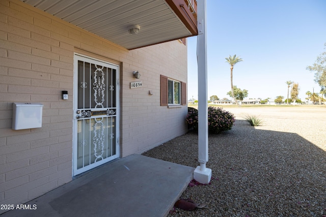 view of exterior entry featuring brick siding