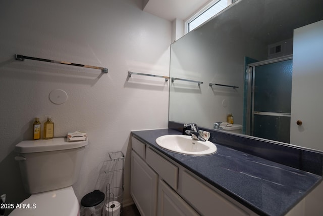 full bath with visible vents, toilet, a stall shower, and vanity