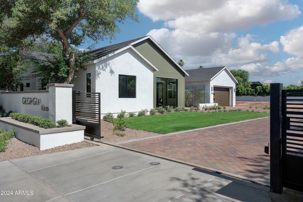 view of front of home with a front lawn, decorative driveway, and stucco siding