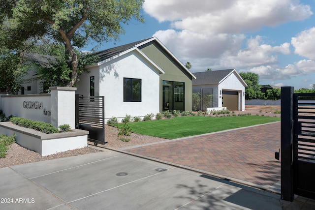 view of front of home with a front lawn, decorative driveway, and stucco siding