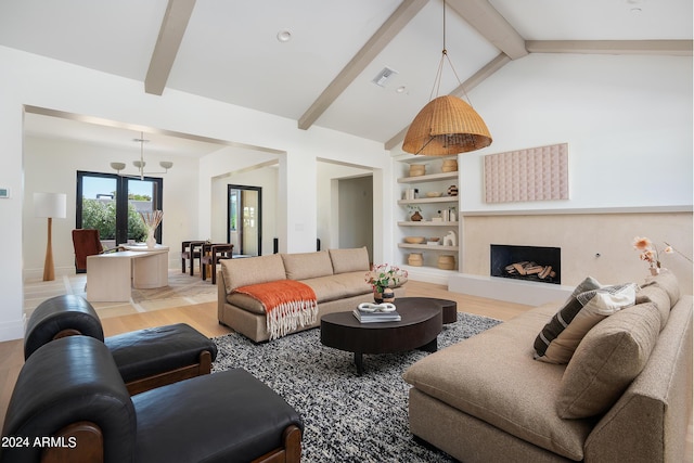 living room with built in features, beam ceiling, a fireplace with raised hearth, visible vents, and wood finished floors