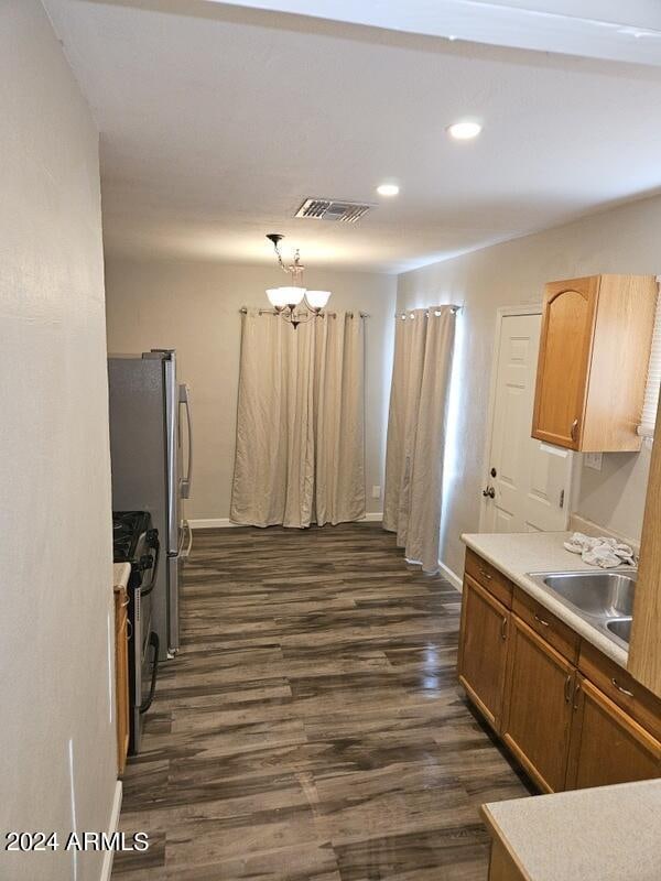 kitchen featuring range, sink, dark hardwood / wood-style flooring, and a notable chandelier