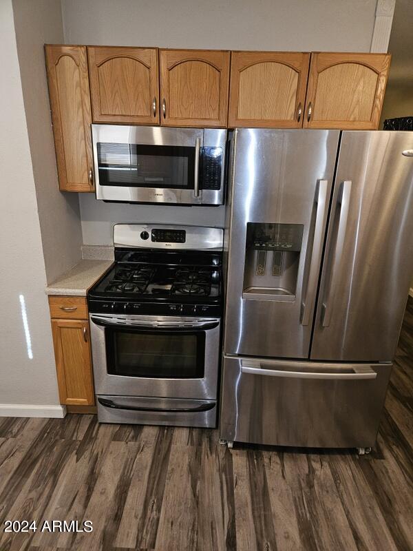 kitchen featuring appliances with stainless steel finishes and dark hardwood / wood-style flooring