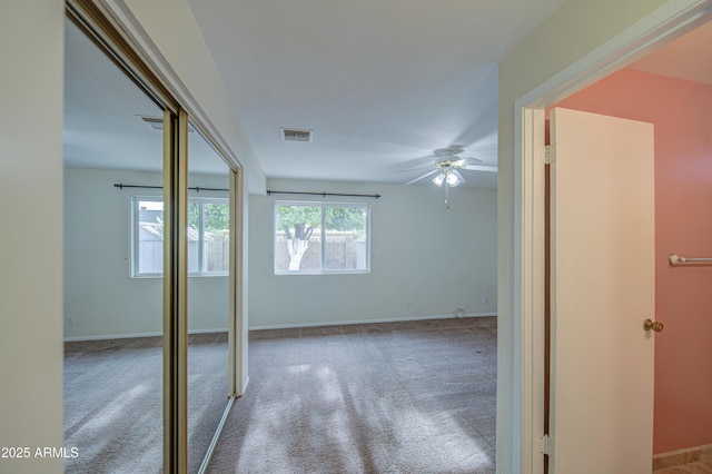 interior space featuring baseboards, ceiling fan, carpet flooring, and visible vents