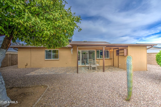 rear view of house featuring fence and a patio area