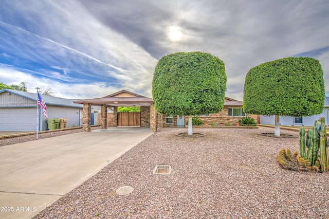 view of front of property featuring a carport, fence, and concrete driveway