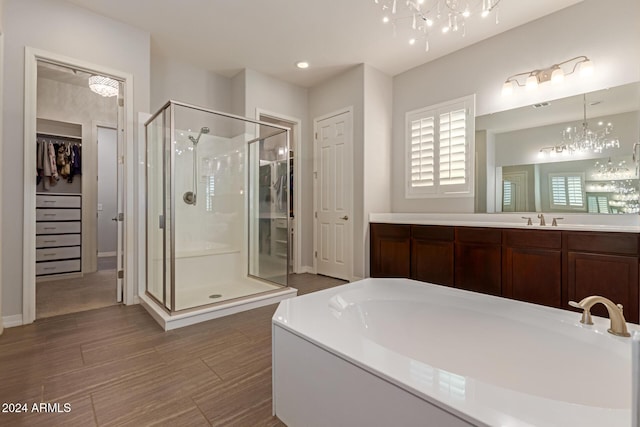 bathroom with plus walk in shower, vanity, and a notable chandelier