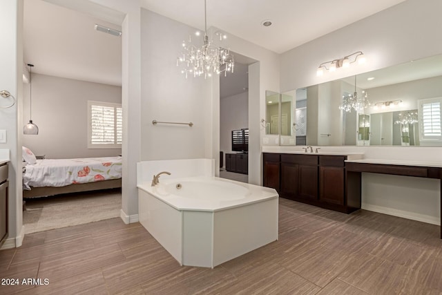 bathroom with a tub to relax in, vanity, and a notable chandelier