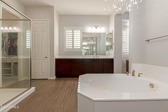 bathroom featuring separate shower and tub, vanity, and an inviting chandelier