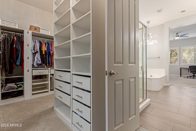 spacious closet featuring ceiling fan and light colored carpet