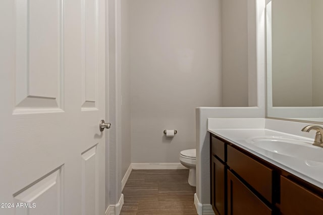 bathroom with vanity, hardwood / wood-style flooring, and toilet