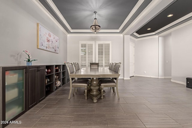 dining area featuring a raised ceiling, crown molding, and a chandelier