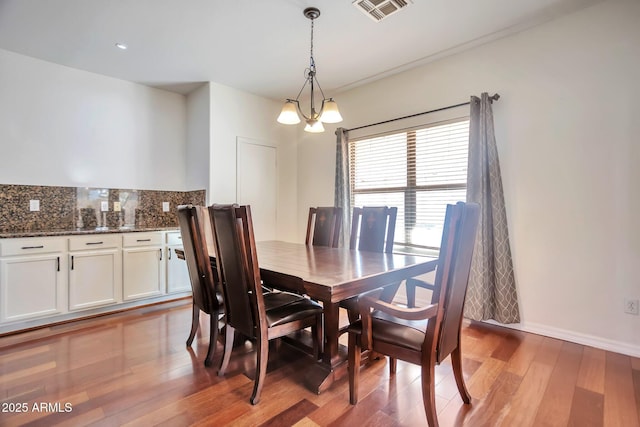 dining room featuring wood-type flooring and a notable chandelier