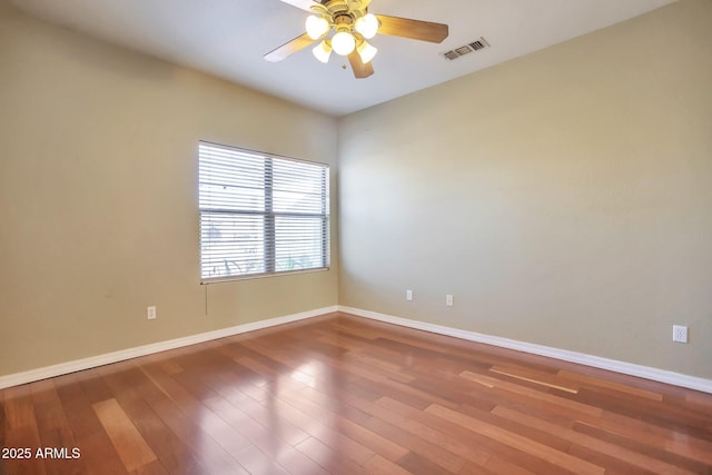 spare room with hardwood / wood-style floors and ceiling fan