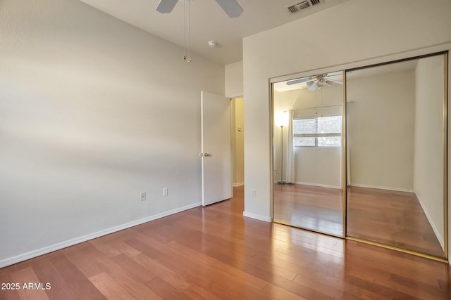 unfurnished bedroom featuring wood-type flooring, a closet, and ceiling fan