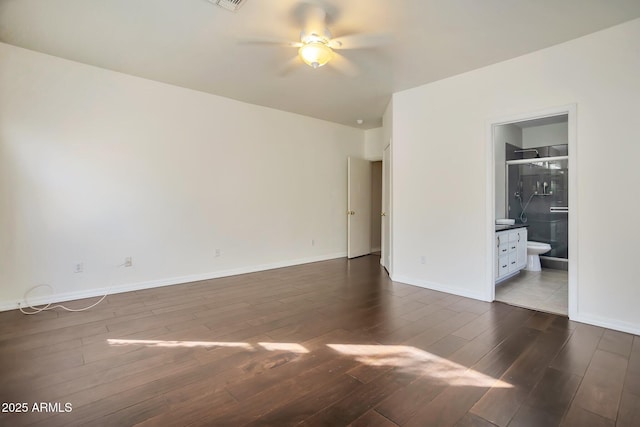 unfurnished bedroom with dark hardwood / wood-style floors, connected bathroom, and ceiling fan