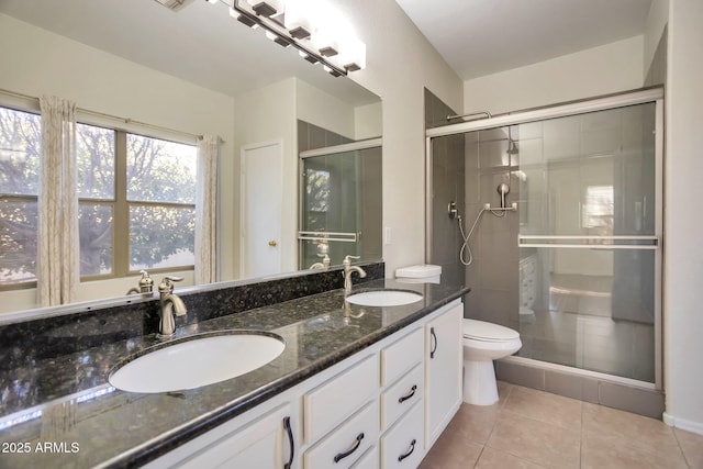 bathroom with tile patterned floors, toilet, a shower with door, and vanity