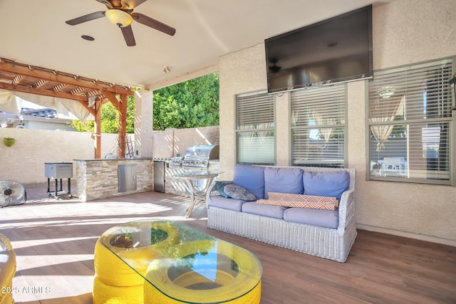 view of patio featuring ceiling fan, a grill, outdoor lounge area, and exterior kitchen