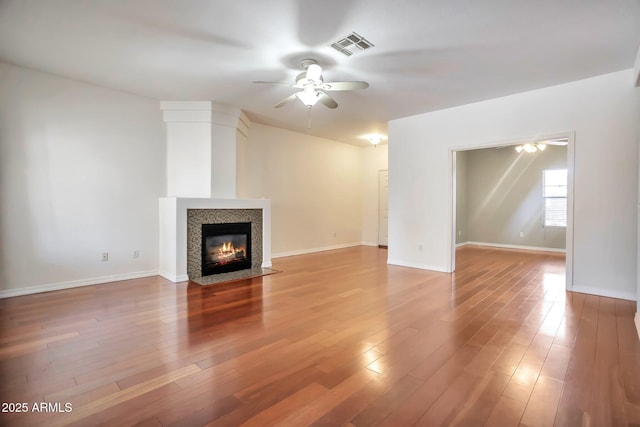 unfurnished living room featuring ceiling fan, hardwood / wood-style floors, and a fireplace