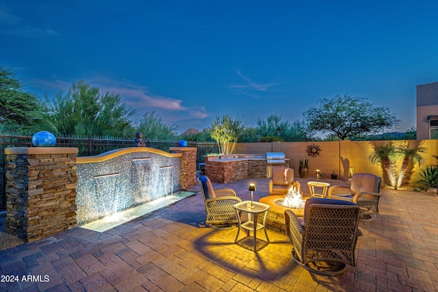 patio terrace at dusk featuring a fire pit