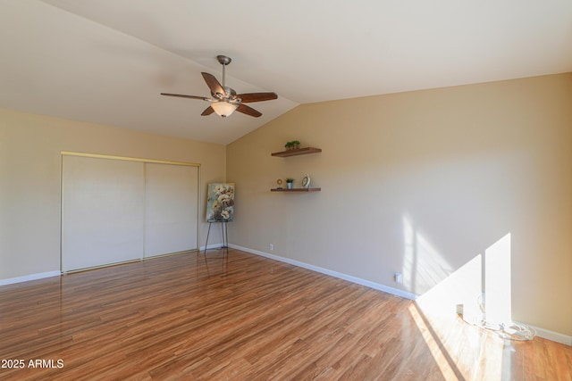 unfurnished bedroom featuring wood-type flooring, vaulted ceiling, a closet, and ceiling fan