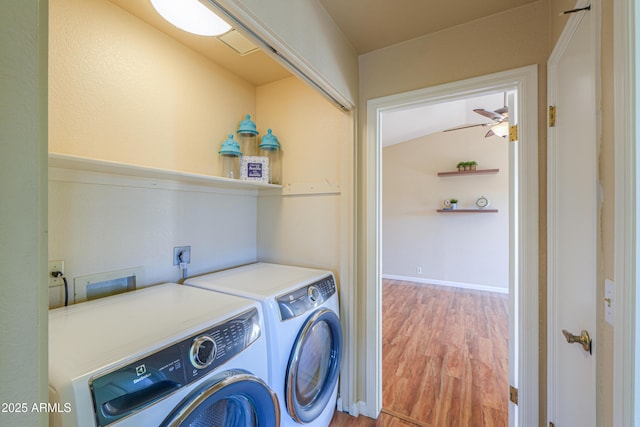 clothes washing area with washing machine and clothes dryer, ceiling fan, and hardwood / wood-style floors