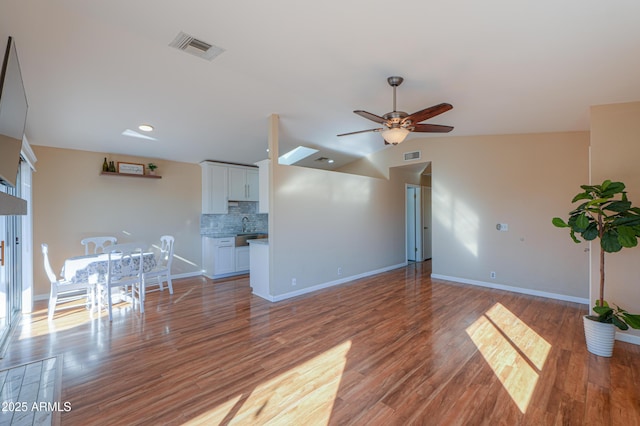 unfurnished living room with wood-type flooring, ceiling fan, lofted ceiling, and sink