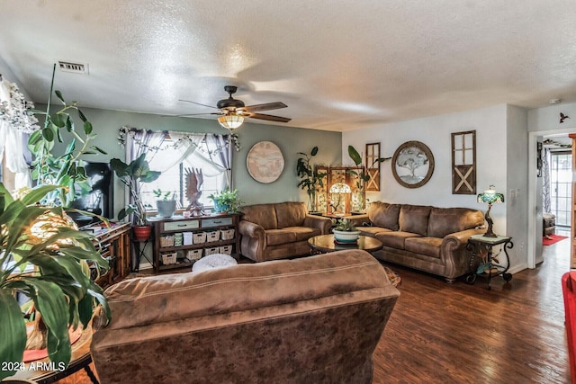 living room with a textured ceiling, ceiling fan, and dark hardwood / wood-style flooring