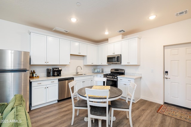 kitchen featuring white cabinetry, sink, hardwood / wood-style flooring, and stainless steel appliances