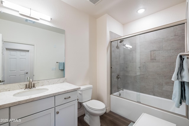 full bathroom featuring vanity, combined bath / shower with glass door, wood-type flooring, and toilet