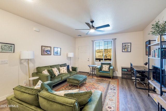 living room featuring ceiling fan and dark hardwood / wood-style floors