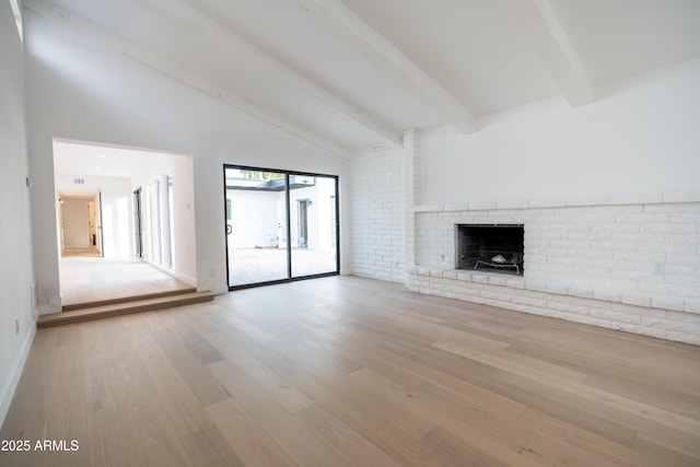 unfurnished living room with beamed ceiling, high vaulted ceiling, a fireplace, and light hardwood / wood-style floors