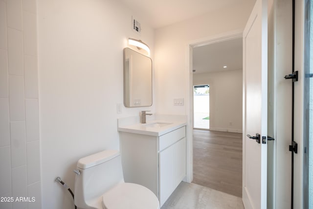 bathroom with vanity, hardwood / wood-style flooring, and toilet