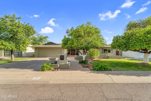 315 E Marlette Ave, Phoenix, AZ 85012 - obstructed view of property featuring a garage, stucco siding, driveway, and a front yard