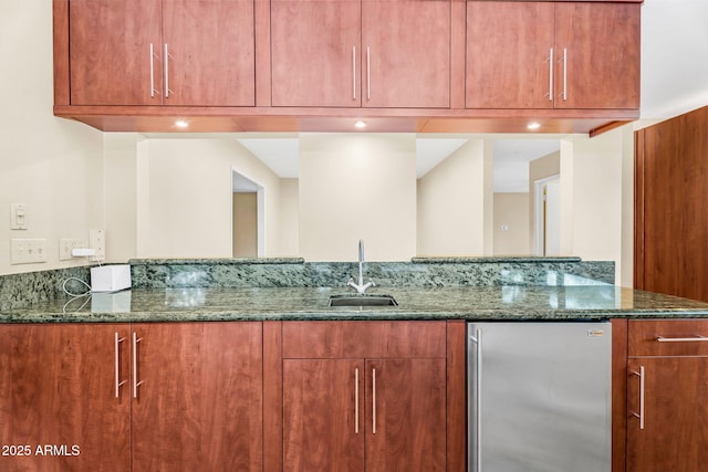 315 E Marlette Ave, Phoenix, AZ 85012 - kitchen featuring a sink, freestanding refrigerator, dark stone counters, and brown cabinets