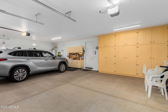 garage featuring a garage door opener and water heater