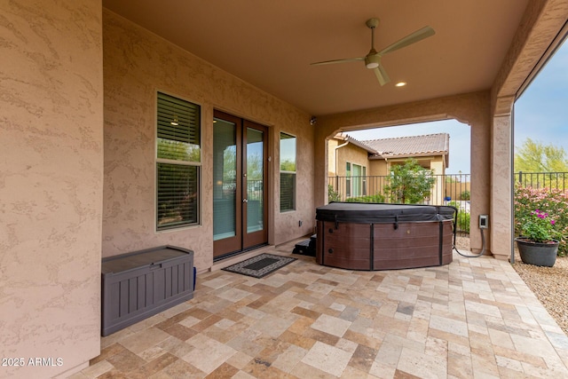 view of patio with ceiling fan and a hot tub