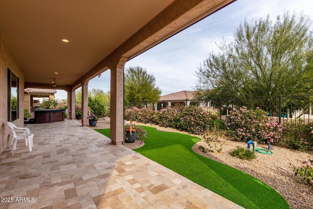 view of patio / terrace featuring ceiling fan and a hot tub