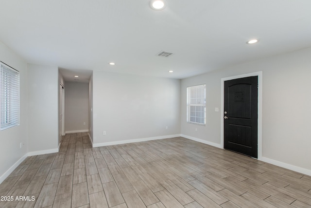 spare room with light wood finished floors, visible vents, recessed lighting, and baseboards