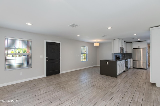 kitchen featuring visible vents, backsplash, dark countertops, white cabinetry, and appliances with stainless steel finishes