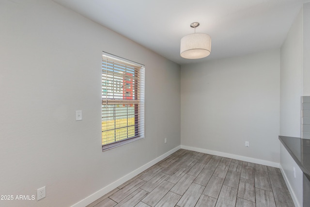 empty room with baseboards and wood tiled floor