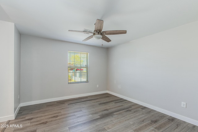 spare room with a ceiling fan, baseboards, and wood finished floors