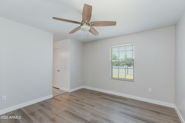 empty room with a ceiling fan, wood finished floors, and baseboards