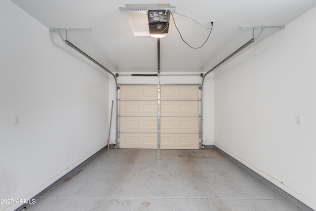 garage featuring a garage door opener and baseboards