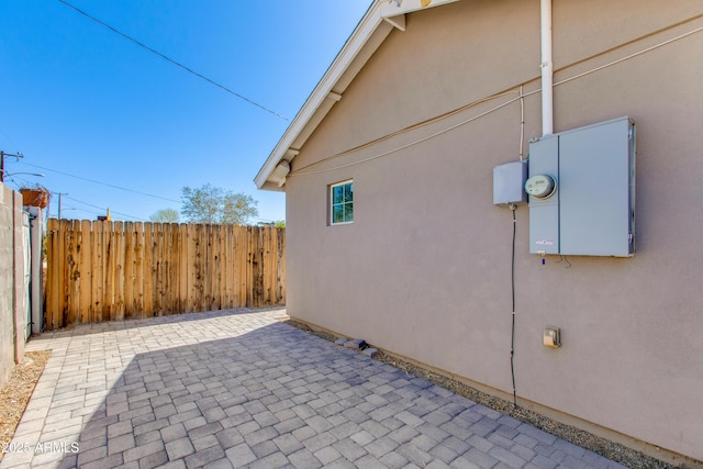 view of property exterior featuring stucco siding, a patio area, and fence