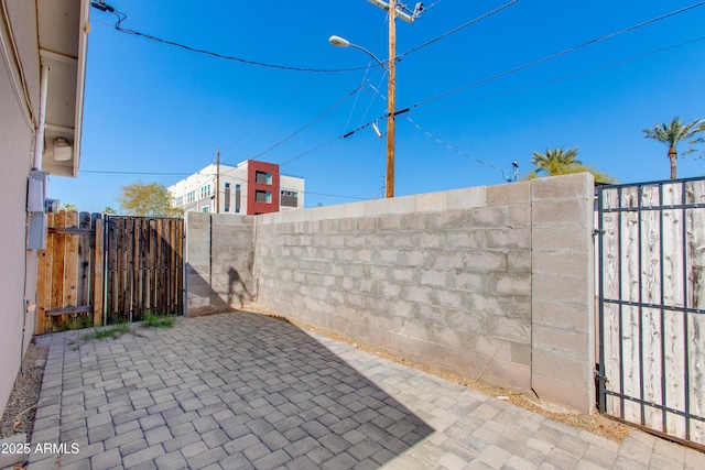 view of patio featuring fence and a gate