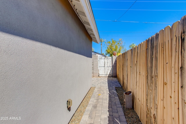 view of property exterior with stucco siding and fence