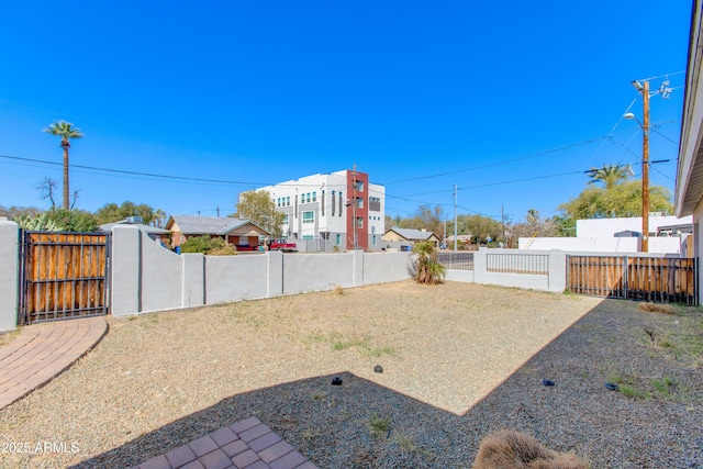 view of yard with a gate and a fenced backyard