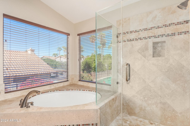 bathroom with a wealth of natural light, separate shower and tub, and vaulted ceiling