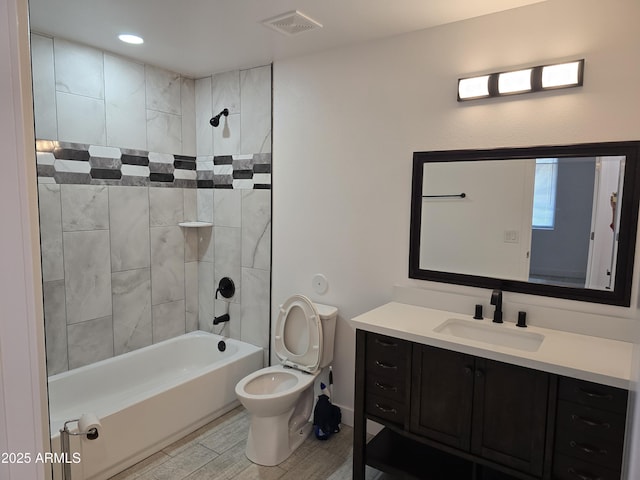 full bath with bathtub / shower combination, visible vents, toilet, vanity, and wood finished floors